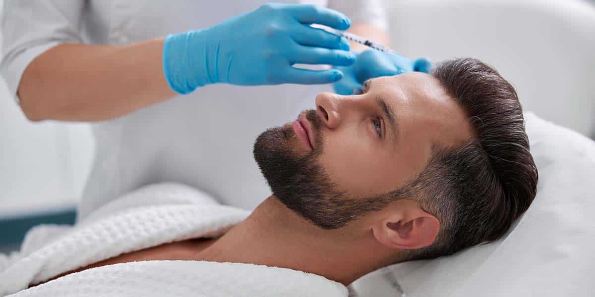 profissional de medicina estética aplicando colagénio na testa de homem - site Episense clínica de medicina estética facial e corporal em Matosinhos, Porto - Portugal